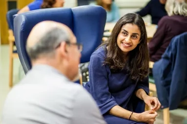 Woman facing the camera speaks with a man 